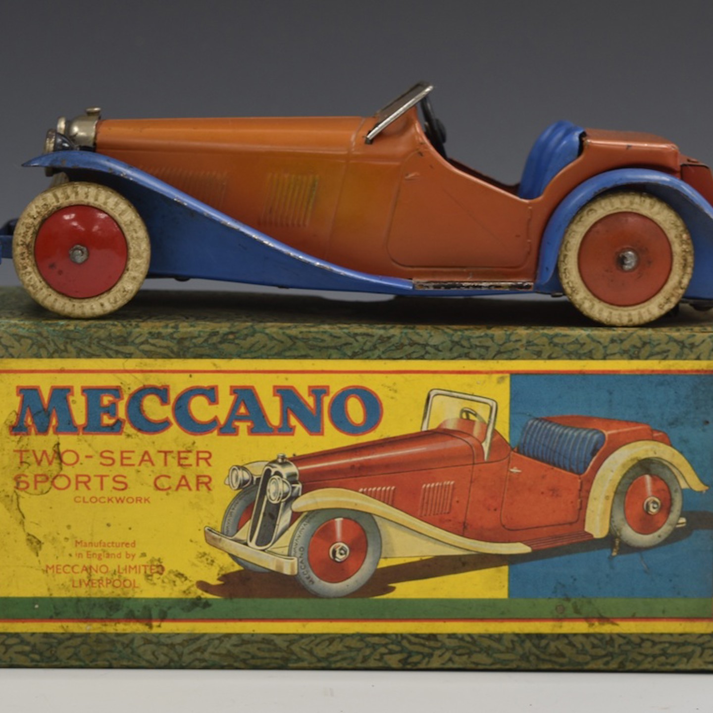 Meccano Clockwork Tinplate Two Seater Sports Car With Red Body And Hubs And Blue Wheel Arches, Bumper And Seats, M223, In Original Box. Sold £500