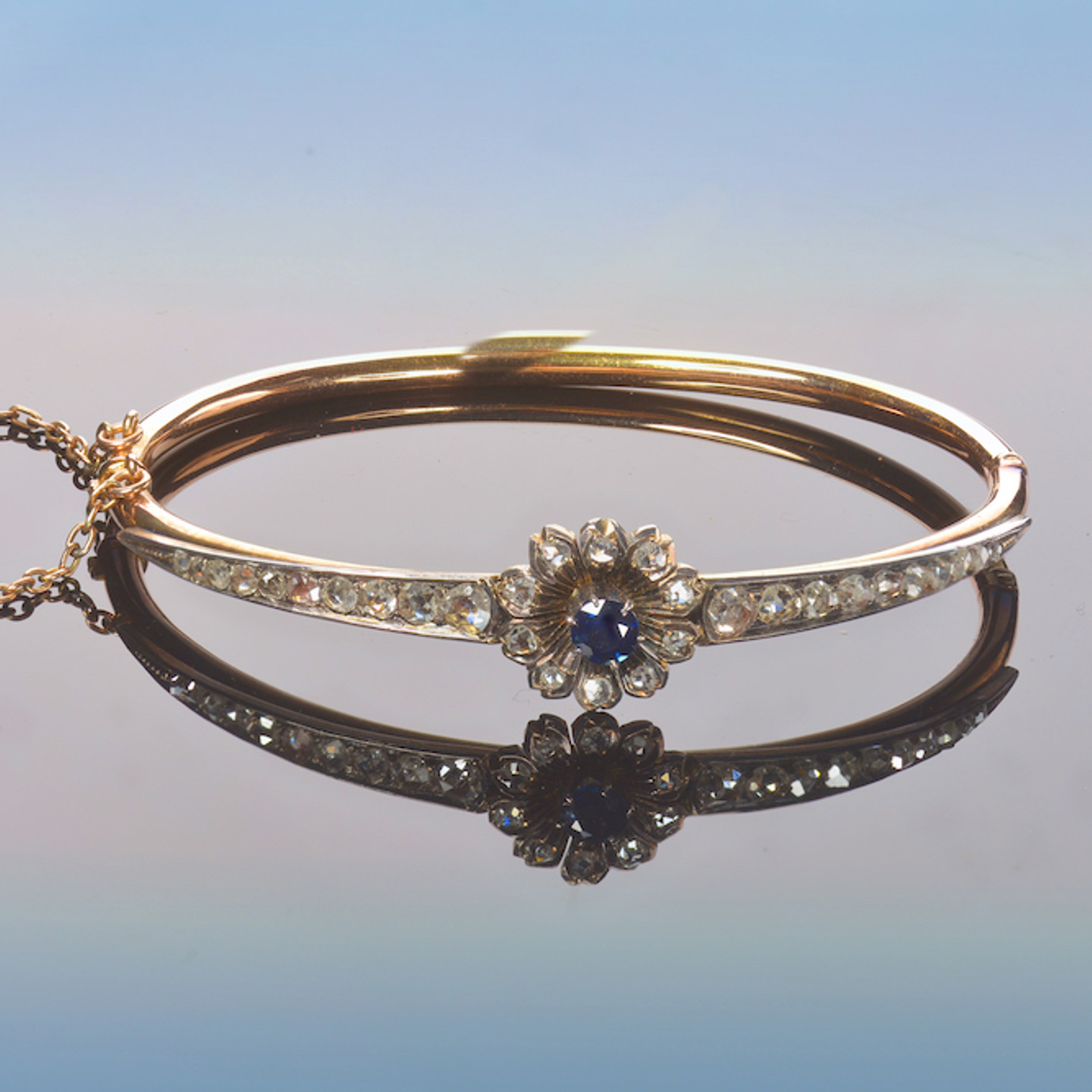 An Early Victorian Gold Bangle Set With A Round Cut Sapphire And Rose Cut Diamonds. Sold For £1,300