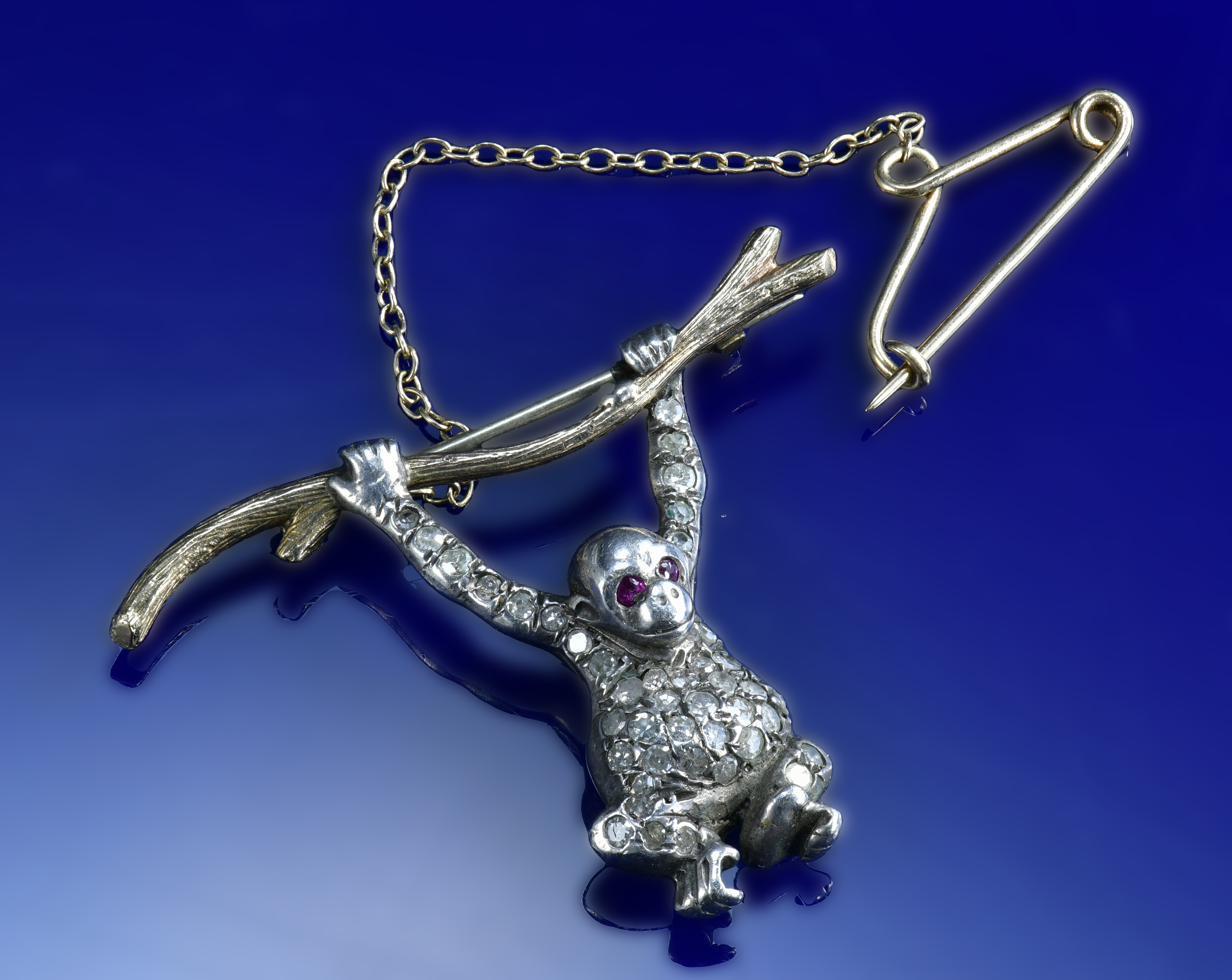 A 9ct gold and silver brooch set with diamonds and rubies in the form of a monkey