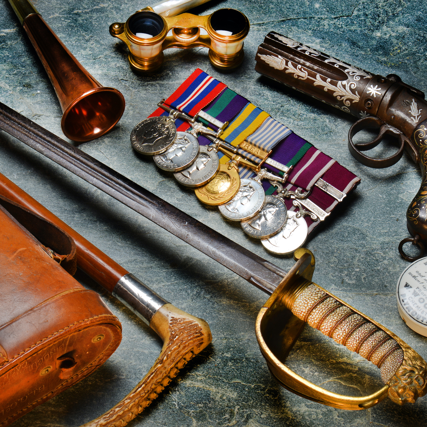 A collection of military antiques, medals, swords and a gun