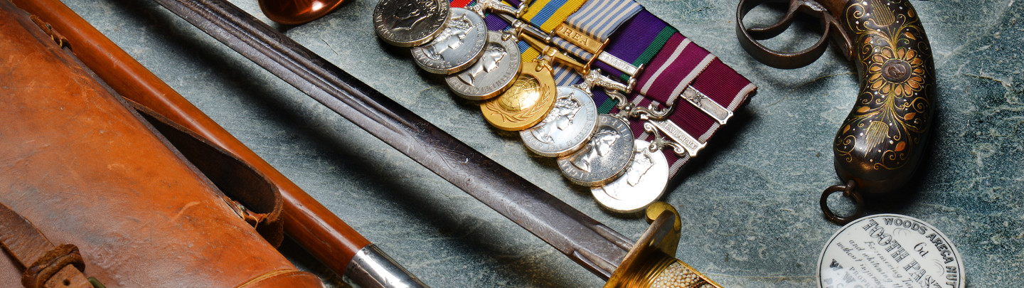 A collection of military antiques, medals, swords and a gun